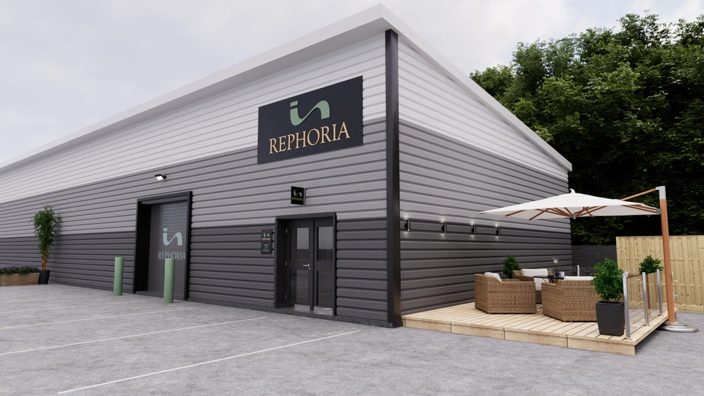 Modern grey and white Rephoria building exterior with outdoor patio seating and entrance doors.